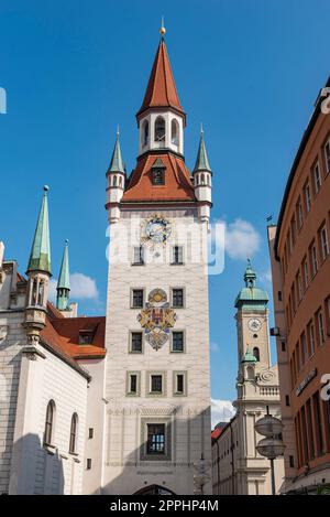 Der Turm des „Alten Rathauses“ im historischen Stadtzentrum von München bei sonnigem Sommerwetter und blauem Himmel mit dem Turm der „Heiligen Geisterkirche“ im Hintergrund Stockfoto