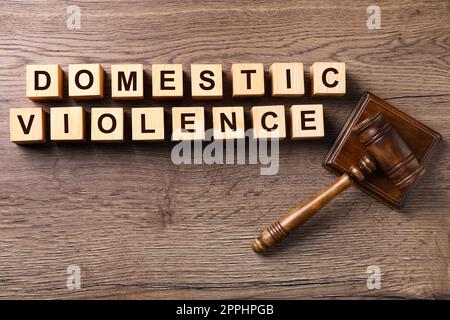 Wooden cubes with words DOMESTIC VIOLENCE and gavel on table, flat lay Stockfoto