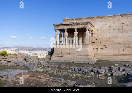 Erechtheion, Tempel der Athena Polias auf der Akropolis von Athen, Griechenland. Blick auf die Veranda der Jungfrauen mit Statuen der Kariatiden. Luftaufnahme der Stadt in der Ferne Stockfoto