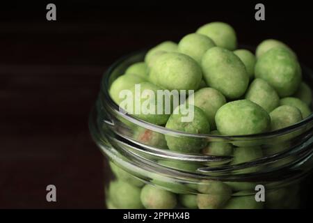 Leckere Wasabi-beschichtete Erdnüsse im Glasglas, Nahaufnahme Stockfoto