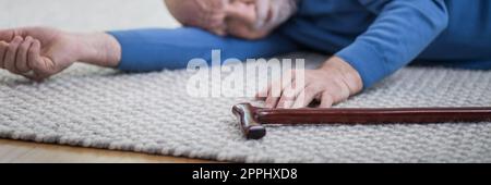 Ein älterer Mann in blauem Pulli lag auf dem Boden seiner Wohnung Stockfoto