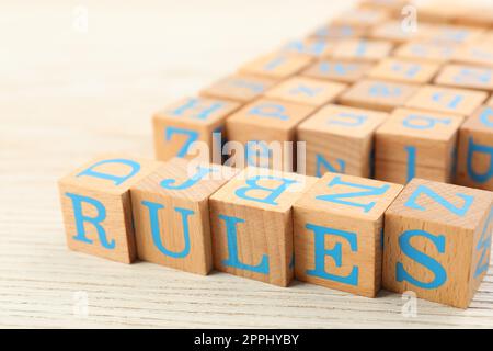 Wortregeln aus Würfeln mit Buchstaben auf einem hellen Holztisch Stockfoto