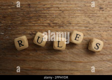 Wortregeln aus Würfeln mit Buchstaben auf einem Holztisch, Draufsicht Stockfoto