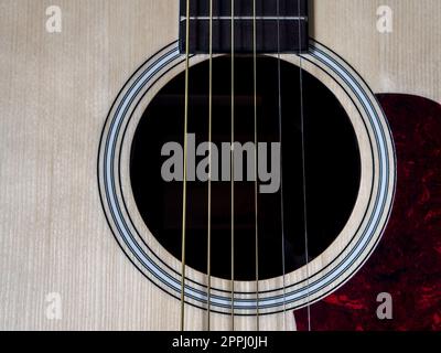 Nahaufnahme der Akustikgitarre. Saiten, Tonloch, Brücke, Pflücker Stockfoto