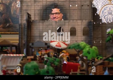 Hanau, Deutschland. 24. April 2023. Boris Rhein (CDU), Ministerpräsident von Hessen, steht hinter einem Playmobil-Diorama des Hambach-Festivals in einer Playmobil-Ausstellung, die 175 Jahre Frankfurts Paulskirche im Hanau History Museum in der Burg Philippsruhe feiert. Die Ausstellung zeigt die Geschichte der deutschen Demokratie in elf Dioramen, die aus Tausenden von Playmobil-Teilen bestehen. Kredit: Sebastian Christoph Gollnow/dpa/Alamy Live News Stockfoto