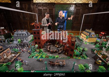 Hanau, Deutschland. 24. April 2023. Boris Rhein (CDU, l), Ministerpräsident von Hessen, und Künstler Oliver Schaffer betrachten ein Diorama von St. Paulus-Kirche in einer Playmobil-Ausstellung zu 175 Jahren Frankfurter St. Paul's Church im Hanau History Museum im Philippsruhe Palace. Die Ausstellung zeigt die Geschichte der deutschen Demokratie in elf Dioramen, die aus Tausenden von Playmobil-Teilen bestehen. Kredit: Sebastian Christoph Gollnow/dpa/Alamy Live News Stockfoto