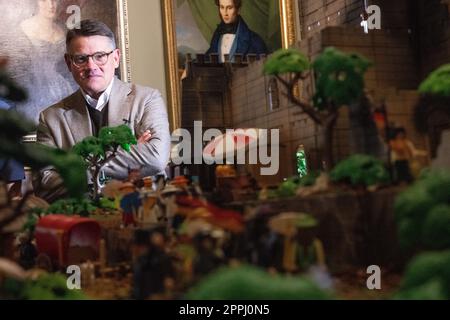 Hanau, Deutschland. 24. April 2023. Boris Rhein (CDU), Ministerpräsident von Hessen, steht hinter einem Playmobil-Diorama des Hambach-Festivals in einer Playmobil-Ausstellung, die 175 Jahre Frankfurts Paulskirche im Hanau History Museum in der Burg Philippsruhe feiert. Die Ausstellung zeigt die Geschichte der deutschen Demokratie in elf Dioramen, die aus Tausenden von Playmobil-Teilen bestehen. Kredit: Sebastian Christoph Gollnow/dpa/Alamy Live News Stockfoto