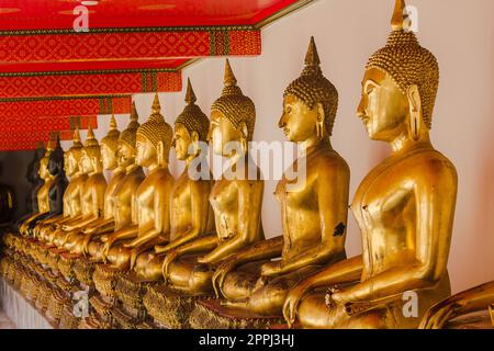 Schöner goldener Buddha auf dem Sockel, einige weiße Wände Stockfoto