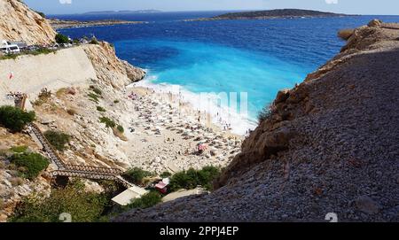 Von der Straße aus hat man einen tollen Blick auf die Menschenmassen, die sich am Strand entspannen. Menschen im Meer schwimmen. Draufsicht auf Kaputas Beach zwischen Kas und Kalkan Stockfoto