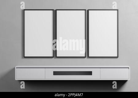 Innenraum, Text oder Produkt zeigen. Rahmensatz aus 3-Modellgalerie mit dünnen Frames auf grauer Wand. Set mit drei Rahmen. Sauber, modern, minimalistisch, hell Stockfoto