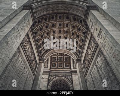 Blick unter den Triumphbogen in Paris, Frankreich. Architektonische Details des berühmten Wahrzeichens Arc de triomphe. Stockfoto