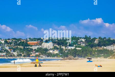 Sonnenstrand Leute Wellen und Boote in Puerto Escondido Mexiko. Stockfoto