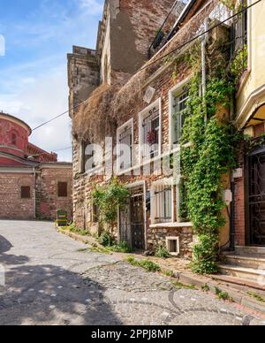 Kopfsteinpflaster-Gasse mit wunderschönen alten, traditionellen roten Backsteinhäusern im Balat-Viertel, an einem Sommertag, Istanbul, Türkei Stockfoto