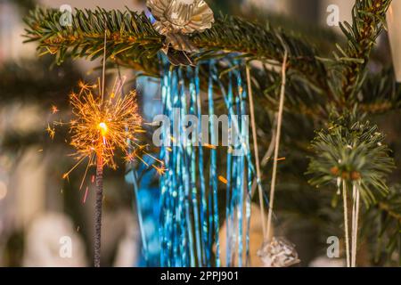 Blaues Lametta und ein brennender Glitzer mit vielen Funken zu weihnachten Stockfoto
