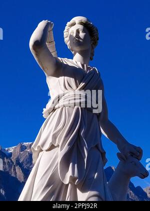 Klassische weiße Marmorstatuette Diana, isoliert auf blauem Himmelshintergrund. Scilpture der Jägerin Stockfoto