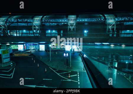 Low-Angle-Aufnahme des DUS-Flughafens und des Skytrain bei Nacht in Düsseldorf Stockfoto