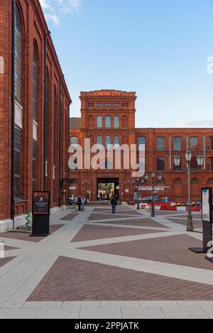 Lodz, Polen - 29. September 2022: Tor zum inneren Platz von Manufaktura bei Sonnenuntergang, einem Kunstzentrum, einem Einkaufszentrum und einem Freizeitkomplex Stockfoto