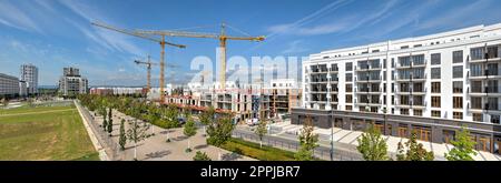 Ein Neubau von Wohnhäusern mit Baukränen und Baustelle im Hintergrund Stockfoto