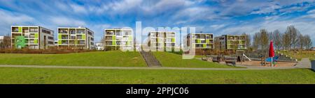 Panoramablick auf moderne Apartmentblöcke mit Spielplatz und Wiese bei Sommerwetter Stockfoto