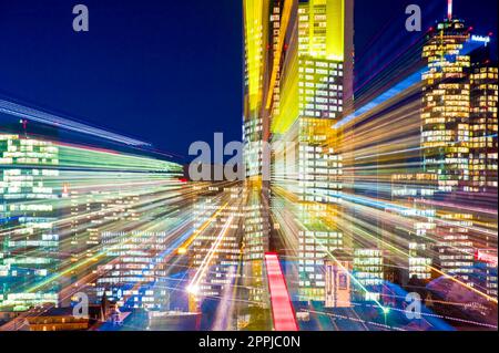 Die künstlich beleuchteten Wolkenkratzer der Skyline von Frankfurt am Main am Abend werden mit Zoomeffekt fotografiert Stockfoto