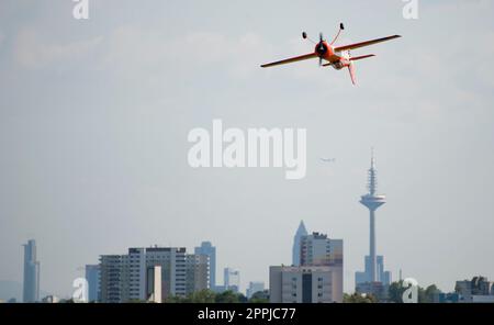 Ein Propellerflugzeug fliegt kopfüber während einer Aerobatikshow vor dem Hintergrund der Frankfurter Wolkenkratzer Stockfoto