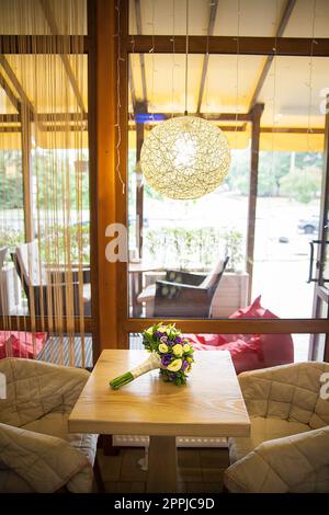 Hochzeitsstrauß mit weißen Blumen auf einem Tisch im Café Stockfoto