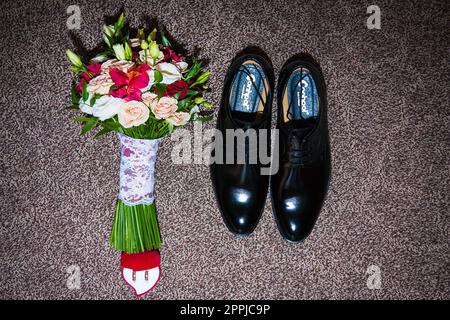 Morgen des Bräutigams. Hochzeitszubehör. Schuhe und Hochzeitsstrauß Stockfoto