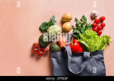 Gesundes Essen. Biologisches Gemüse, vegane vegetarische rohe Lebensmittelzutaten in Textilbeutel auf beigefarbenem Hintergrund, Kopierbereich. Lieferungs- oder Supermarktketten Stockfoto