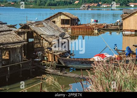 Gescannte Folie mit historischem Farbfoto von Fischerbooten, die in einer Siedlung am Ufer eines Sees im Zentrum Vietnams anlegen Stockfoto