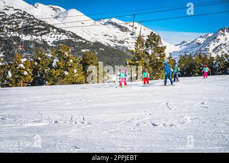 Skilehrer, der einer Gruppe kleiner Kinder das Skifahren in El Tarter, Andorra beibringt Stockfoto