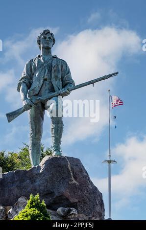 Minute man Statue und US-Flagge in Battle Green im historischen Stadtzentrum von Lexington Stockfoto