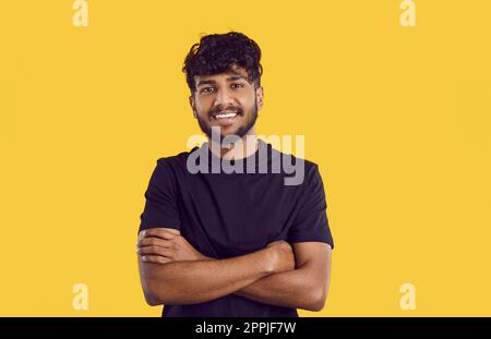 Portrait eines gutaussehenden, lächelnden jungen indianers mit einem wunderschönen Lächeln isoliert auf orangefarbenem Hintergrund. Stockfoto
