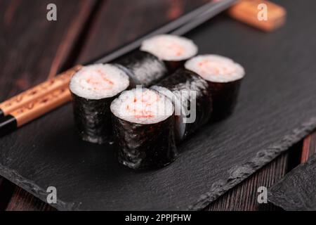 Maki Shrimp Sushi Nahaufnahme. Garnelenfiletfüllung, verpackt in Reis und Nori-Algen. Japanische Küche Stockfoto