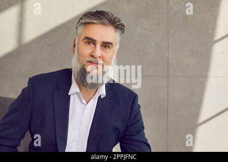 Porträt eines gutaussehenden, grauhaarigen, bärtigen Geschäftsmanns mittleren Alters Stockfoto