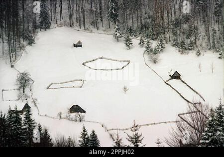 Brasov County, Rumänien, ca. 1999. Winterlandschaft in den Bergen. Abgelegene, eingezäunte landwirtschaftliche Grundstücke. Stockfoto