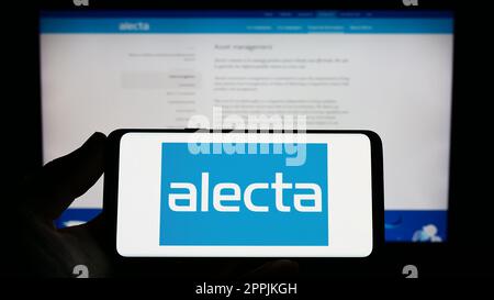 Person, die ein Smartphone mit dem Logo der schwedischen Rentenversicherung Alecta auf dem Bildschirm vor der Website hält. Konzentrieren Sie sich auf das Display des Telefons. Stockfoto