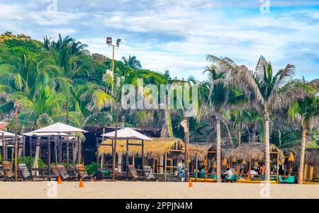 Palmen Sonnenschirme Sonnenliegen Strandresort Zicatela Puerto Escondido Mexiko. Stockfoto