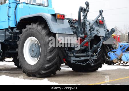 Räder der Rückansicht des neuen Traktors bei schneebedecktem Wetter. Rückansicht des landwirtschaftlichen Fahrzeugs Stockfoto