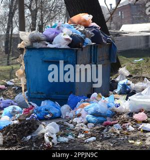 Die Mülltonne ist mit Müll und Abfall verpackt. Vorzeitige Beseitigung von Müll in bewohnten Gebieten Stockfoto