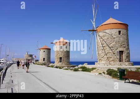 RHODOS, GRIECHENLAND - 10. MAI 2022: Mandraki Marina und Hafen mit Rhodos Windmühlen, Griechenland Stockfoto