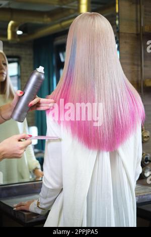 Schöne blonde Mädchen mit farbigen rosa Haar in einem Friseursalon. Stockfoto