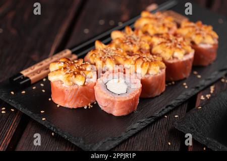 Sushi Roll philadelphia mit Lachs und Frischkäse auf schwarzem Hintergrund aus nächster Nähe. Sushi-Menü. Japanisches Speisekonzept Stockfoto