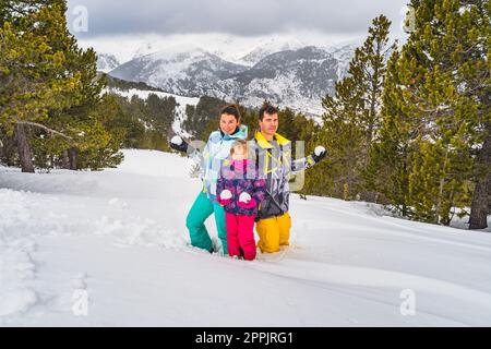 Die Familie hält Schneebälle und ist bereit für einen Schneekampf. Skiurlaub im Winter in Andorra Stockfoto