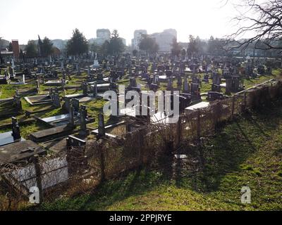 Sremska Mitrovica, Serbien, 25. Februar 2021. Christliche Stadt, moderner Friedhof. Gräber mit Steindenkmälern und Kreuzen. Grabsteine aus Granit. Krypta oder Kapelle. Beerdigungs- oder Halloween-Thema Stockfoto