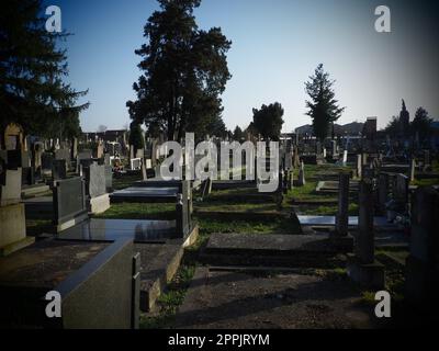 Sremska Mitrovica, Serbien, 25. Februar 2021. Christliche Stadt, moderner Friedhof. Gräber mit Steindenkmälern und Kreuzen. Grabsteine aus Granit. Krypta oder Kapelle. Beerdigungs- oder Halloween-Thema Stockfoto