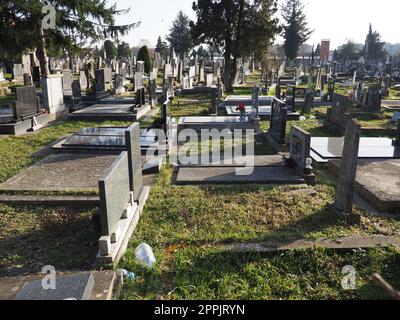 Sremska Mitrovica, Serbien, 25. Februar 2021. Christliche Stadt, moderner Friedhof. Gräber mit Steindenkmälern und Kreuzen. Grabsteine aus Granit. Krypta oder Kapelle. Beerdigungs- oder Halloween-Thema Stockfoto