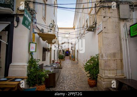 Blick auf eine gemütliche Straße mit Restaurants und Bars in der Altstadt von Faro, Porutgal Stockfoto