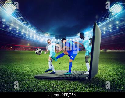 Fußballspieler spielen auf einem Laptop, das Konzept des tv-Streamings Stockfoto