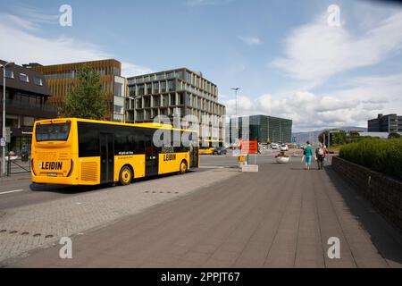 Blick auf die Laekjargata, Harpa-Museum im Hintergrund, gelber öffentlicher Verkehrsbus Besta Leidin im Vordergrund Stockfoto