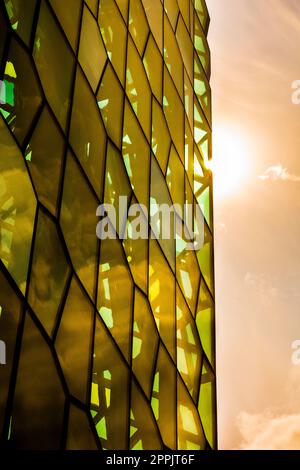 Architektur-Nahaufnahme und Detail der Glasfenster-Gestaltung des Konzerthauses und Konferenzzentrums Harpa mit der Sonne, die Farben in den Fenstern formt Stockfoto